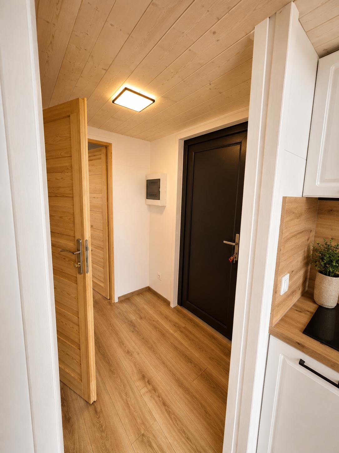 Entré med inngangsdør, sikringsskap og dør inn til soverom